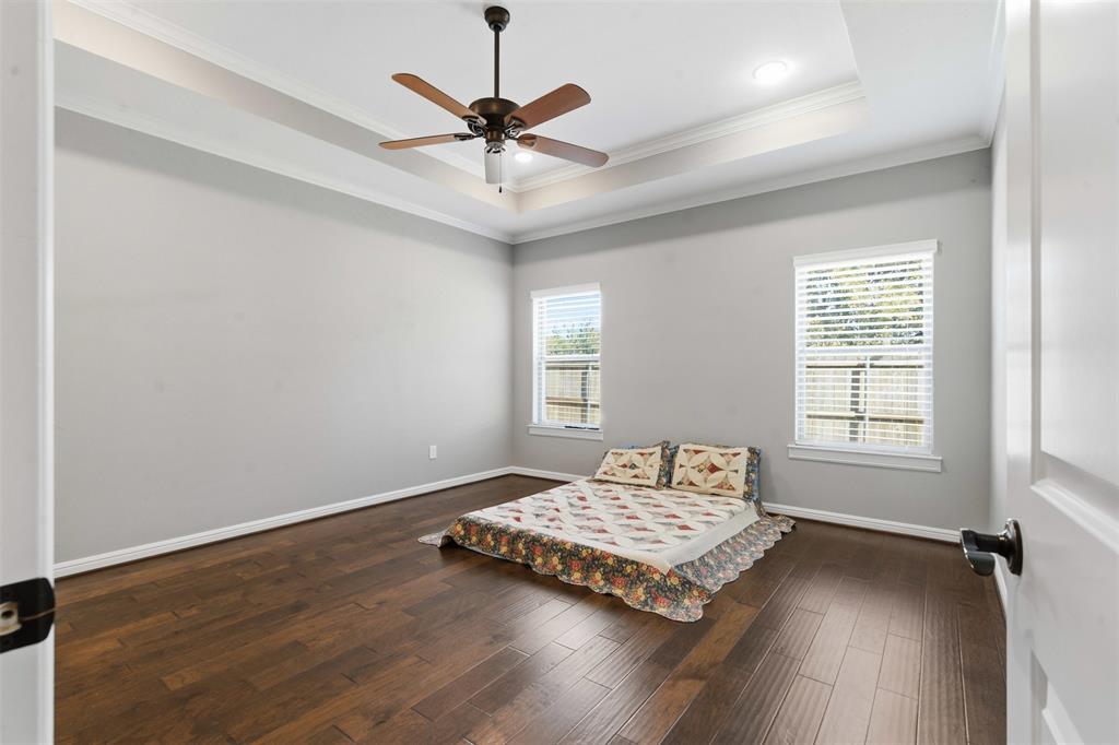 1617 Hawthorne Street Cleburne, TX 76033 - Photo 27 of 40 a bedroom with a bed and wooden floor