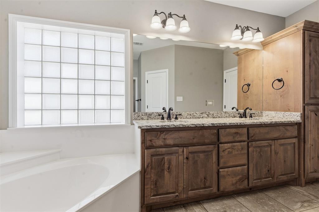 1617 Hawthorne Street Cleburne, TX 76033 - Photo 31 of 40 a bathroom with a tub sink and mirror