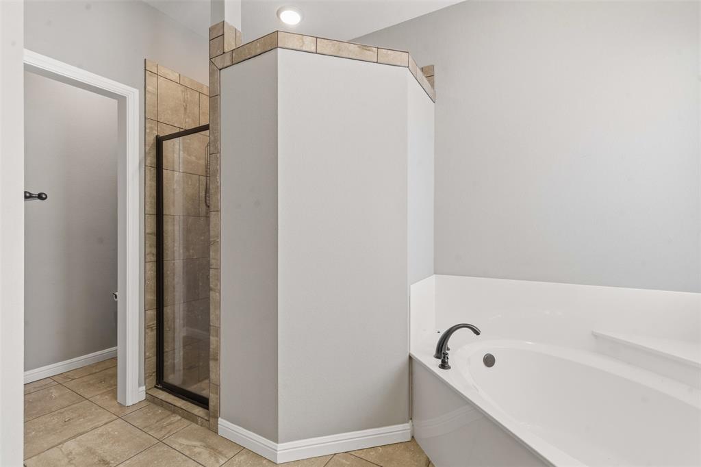 1617 Hawthorne Street Cleburne, TX 76033 - Photo 33 of 40 a bathroom with a bathtub and a shower