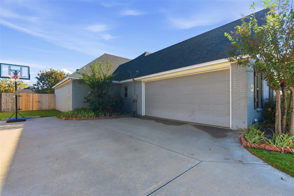 1617 Hawthorne Street Cleburne, TX 76033 - Photo 7 of 40 a backyard of a house with plants and trees