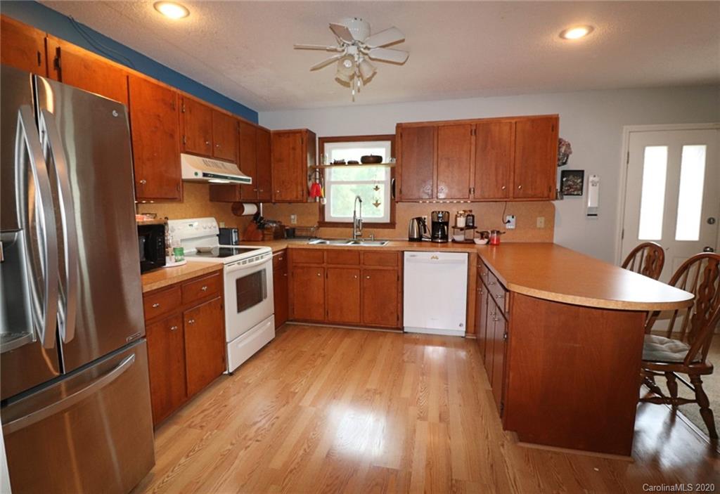 4693 Cureton Ferry Road Catawba, SC 29704 - Photo 14 of 25 a kitchen with stainless steel appliances a refrigerator a sink dishwasher a stove top oven a refrigerator with island and chairs