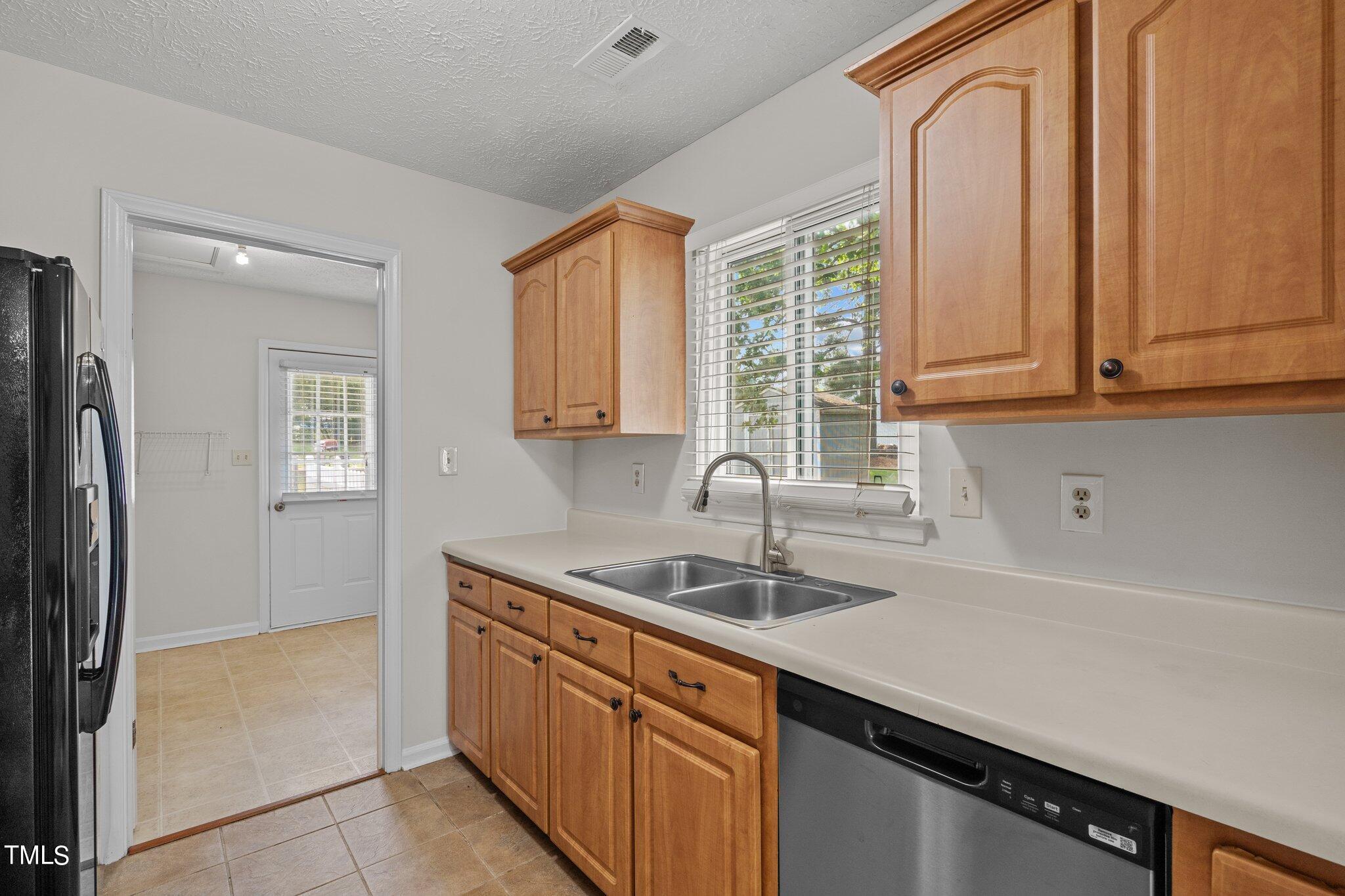 5104 Duckworth Court Raleigh, NC 27616 - Photo 11 of 36 a kitchen with stainless steel appliances granite countertop a sink a refrigerator and a granite counter tops with a window