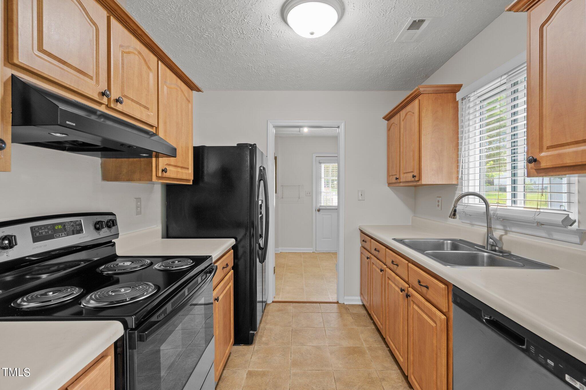 5104 Duckworth Court Raleigh, NC 27616 - Photo 9 of 36 a kitchen with stainless steel appliances granite countertop a sink stove and refrigerator