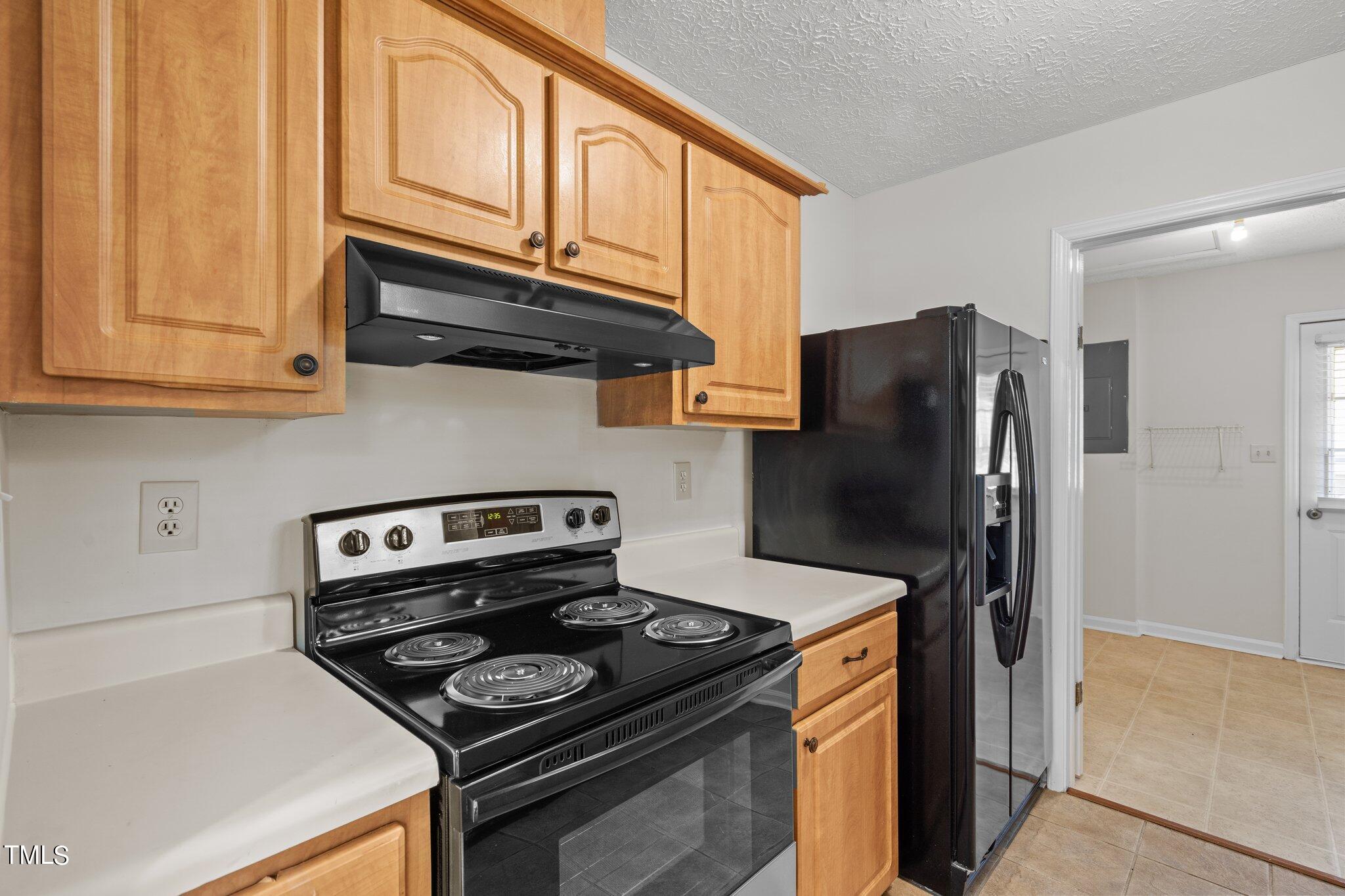 5104 Duckworth Court Raleigh, NC 27616 - Photo 10 of 36 a kitchen with stainless steel appliances granite countertop a stove and a refrigerator with white cabinets