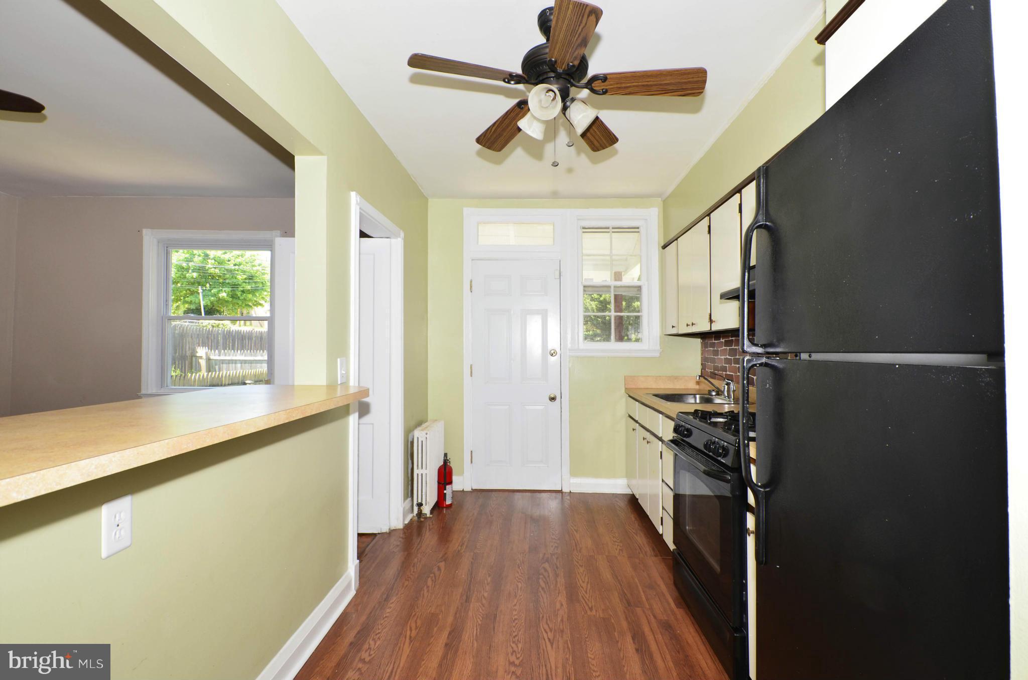 5226 Cromarty Road Baltimore, MD 21229 - Photo 14 of 30 a kitchen with a refrigerator a stove top oven a sink and wooden floor