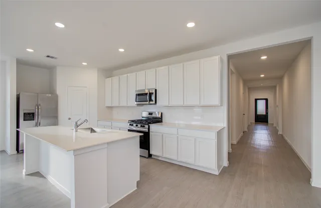 a kitchen with stainless steel appliances a sink stove and cabinets