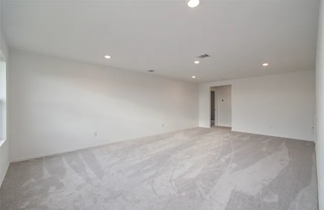a living room with furniture kitchen view and a large window
