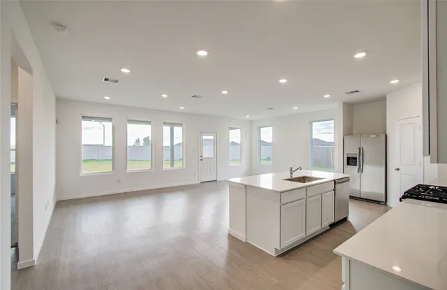 a large kitchen with kitchen island a sink stainless steel appliances and cabinets