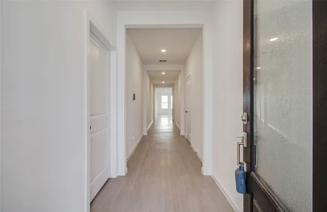 a view of a hallway with wooden floor and staircase