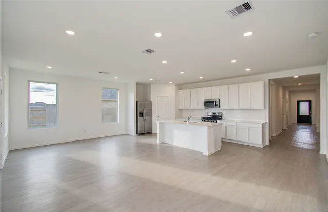 a view of kitchen with center island stainless steel appliances refrigerator sink and cabinets