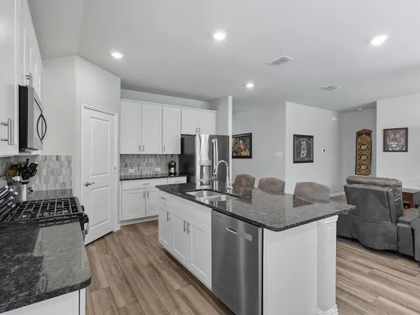 a kitchen with stainless steel appliances granite countertop a sink stove and refrigerator