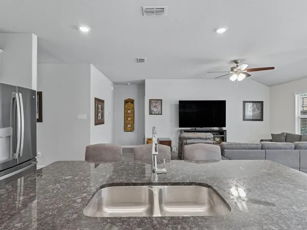 a kitchen island with a sink stainless steel appliances and a counter top space