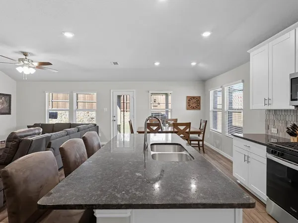 a living room with furniture two window and wooden floor