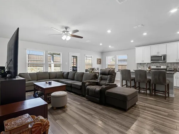 a living room with furniture kitchen view and a window