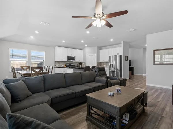 a living room with furniture and a view of kitchen