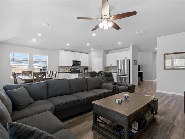 a living room with furniture and a view of kitchen
