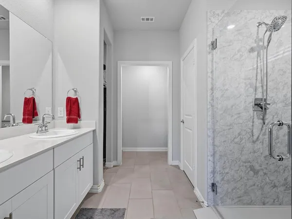 a bathroom with a sink vanity and shower