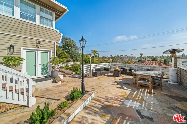 a view of a patio with a dining table and chairs with wooden floor and fence