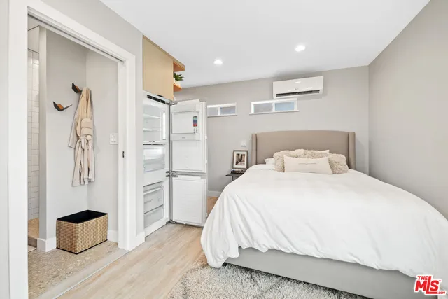 a bedroom with a bed and a refrigerator