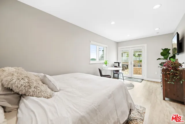 a bedroom with a large bed and a potted plant