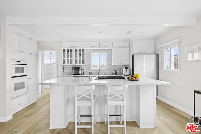 a kitchen with stainless steel appliances a white stove top oven cabinets and a refrigerator