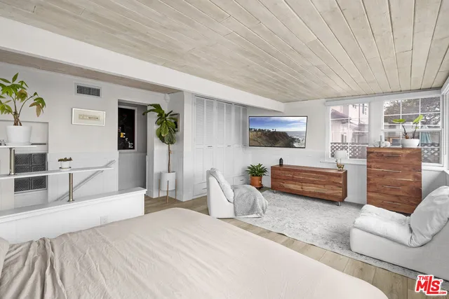 a bedroom with furniture and a flat screen tv