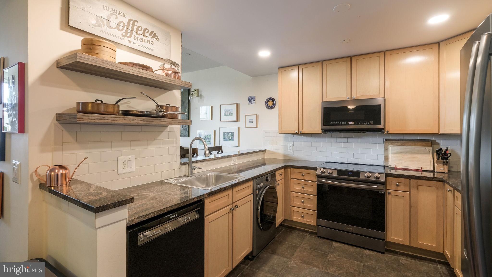 a kitchen with stainless steel appliances granite countertop a sink stove and cabinets