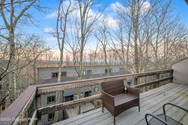 a view of a roof deck with couches and wooden fence