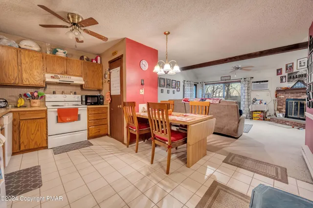 a kitchen with stainless steel appliances kitchen island granite countertop a table chairs and a refrigerator