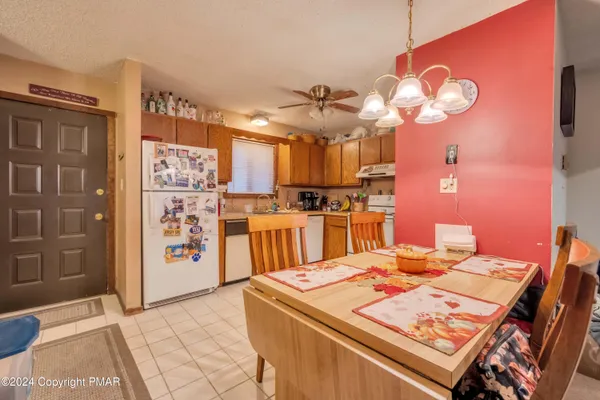 a open kitchen with a refrigerator a stove a sink and a dining table