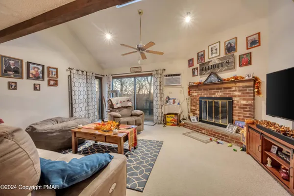 a bedroom with furniture a flat screen tv and a fireplace