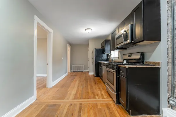 a kitchen with stainless steel appliances granite countertop a refrigerator a stove and a microwave