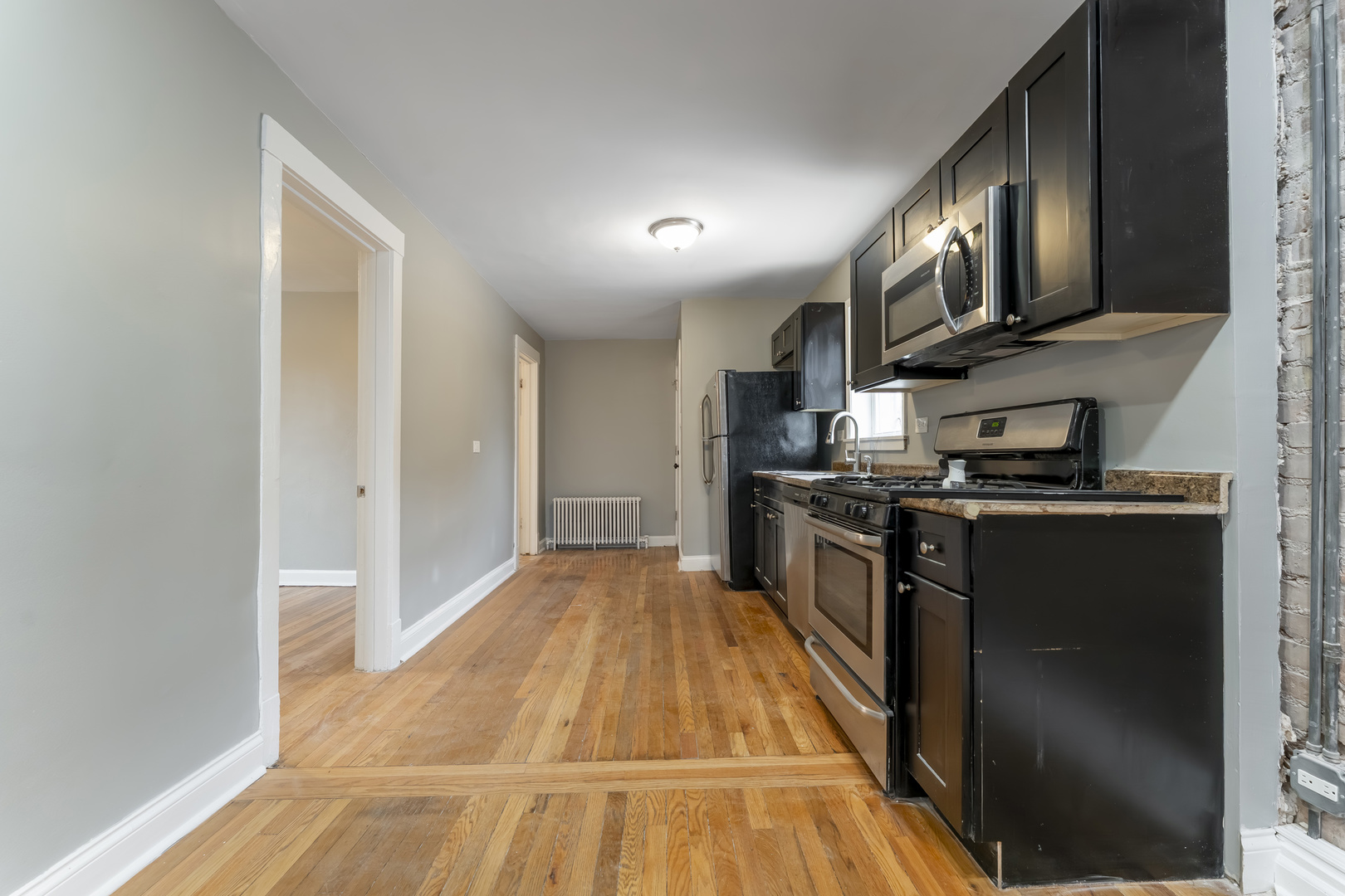 3908 West Montrose Avenue, Unit 2R Chicago, IL 60618 - Photo 3 of 10 a kitchen with stainless steel appliances granite countertop a refrigerator a stove and a microwave