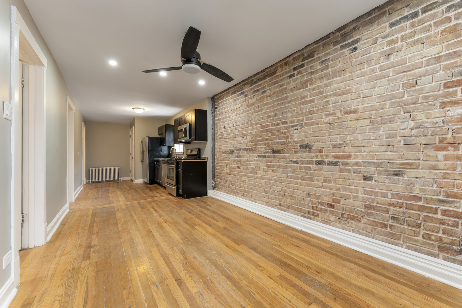 3908 West Montrose Avenue, Unit 2R Chicago, IL 60618 - Photo 5 of 10 a view of empty room with kitchen and wooden floor