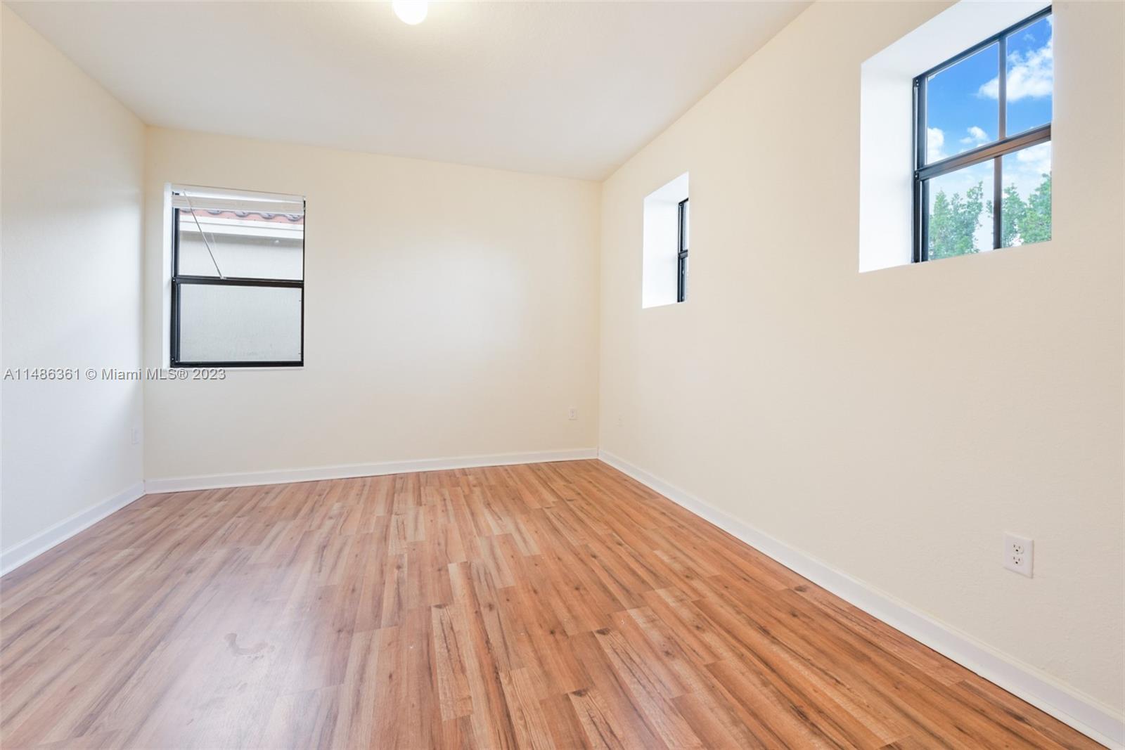 15218 Southwest 173rd Lane Miami, FL 33187 - Photo 12 of 14 an empty room with wooden floor and windows
