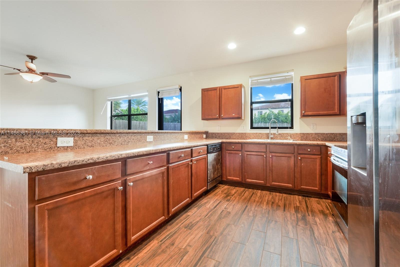15218 Southwest 173rd Lane Miami, FL 33187 - Photo 5 of 14 a kitchen with stainless steel appliances granite countertop a sink and wooden cabinets
