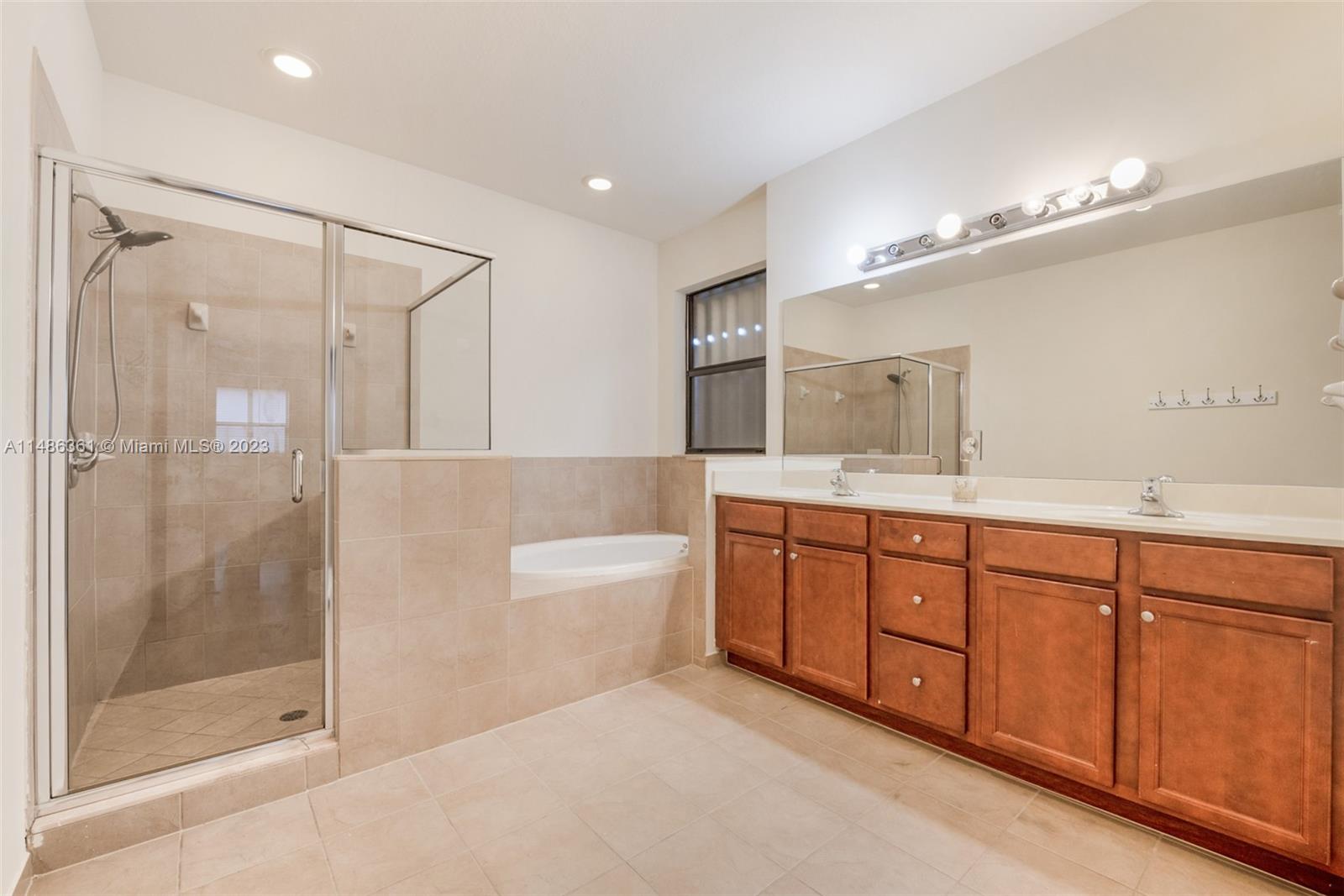 15218 Southwest 173rd Lane Miami, FL 33187 - Photo 6 of 14 a spacious bathroom with a tub sink shower and mirror
