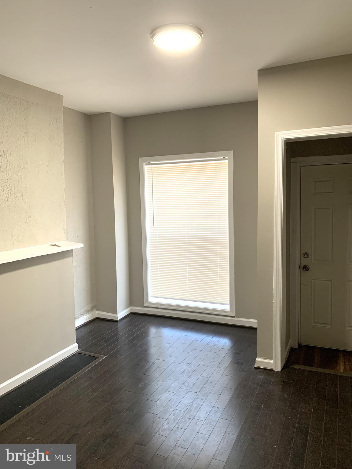 2708 Mathews Street Baltimore, MD 21218 - Photo 4 of 20 an empty room with wooden floor and windows