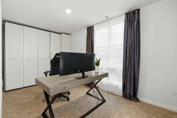 a view of a workspace with furniture and a window