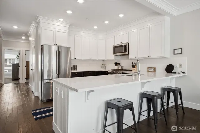 a kitchen with a dining table chairs refrigerator and cabinets