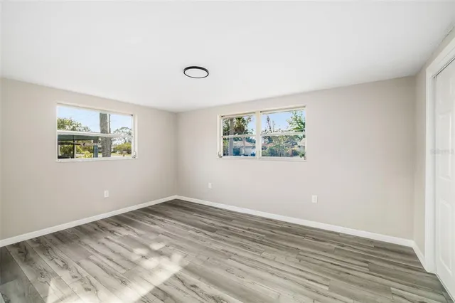 a view of empty room with wooden floor