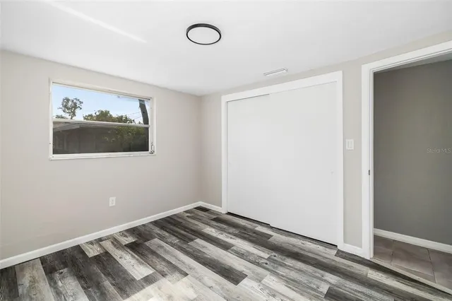 a view of a room with wooden floor and a window
