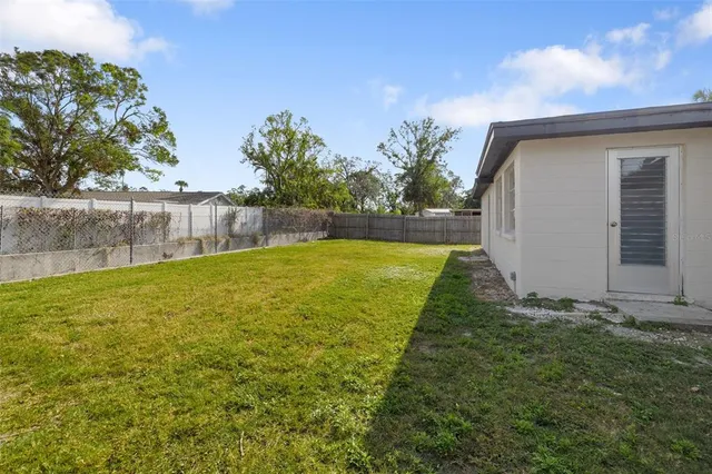 a view of backyard with swimming pool and seating area