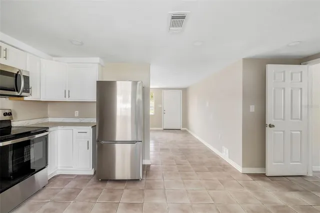 a kitchen with granite countertop a refrigerator and a stove top oven