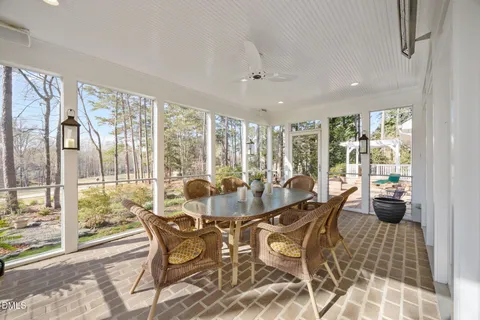 a dining room with furniture a chandelier and wooden floor