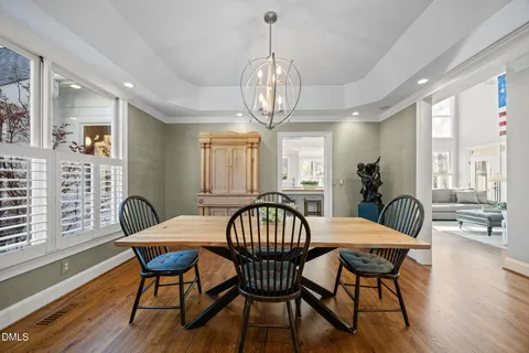 a view of a dining room with furniture a chandelier and wooden floor