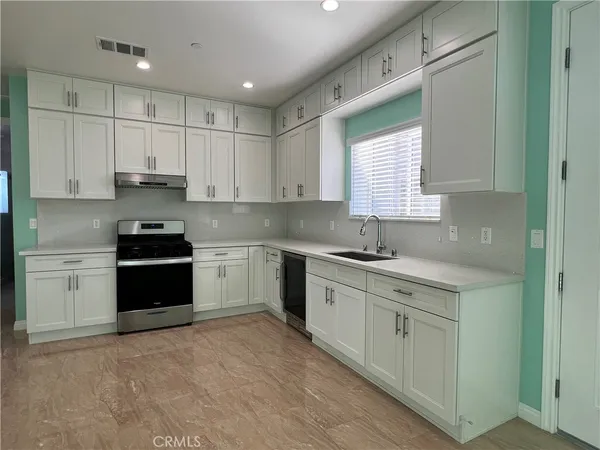 a kitchen with granite countertop white cabinets white appliances and granite counter tops