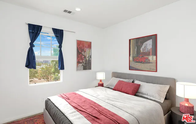 a bedroom with a bed and a painting on the wall