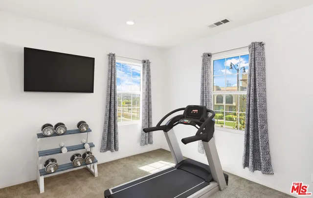 a view of a workspace with furniture and a window