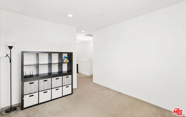 a view of a patio with couches chairs under an umbrella with a fire pit